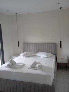 ペフコホリにあるVilla Glarokavos by Golden Residenceのタオルが敷かれた白いベッドのある寝室
