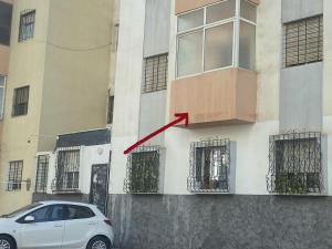 Un coche blanco aparcado delante de un edificio en Appartement confortable et ensoleillée, en Aïn Harrouda