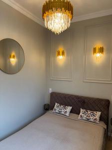 una camera da letto con un letto e un lampadario di Centre GRANT Apartment a Klaipėda