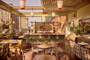 a restaurant with tables and chairs and a bar at Conrad New York Downtown in New York