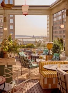 a patio with tables and chairs on a balcony at Conrad New York Downtown in New York