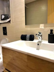 a bathroom with a white sink and a mirror at Studio et place parking gratuite in Casablanca +6 photos