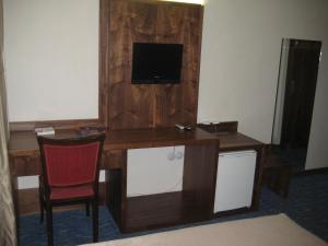 a room with a desk with a television and a chair at Miroglu Hotel in Diyarbakır
