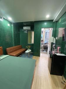 a living room with green tiled walls and a couch at PAPAYA HOTEL & Café 2 in Ho Chi Minh City