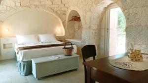 a bedroom with a bed and a table and a desk sidx sidx sidx at I Trulletti del Gelso a Masseria Santalachicca in Masseria Orimini