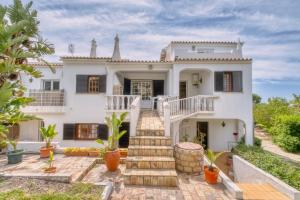 a house with a staircase leading up to it at Casa Teles in Quarteira