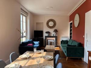 a living room with a table and a couch at L'AUTHENTIQUE in Saint-Brieuc +7 photos