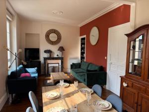 a living room with a table and a couch at L'AUTHENTIQUE in Saint-Brieuc