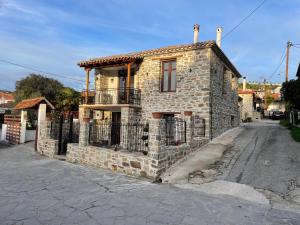 ニキティにあるVilla Stavros Nikiti by BookVillaEUの通りに面した柵のある古い石造りの家