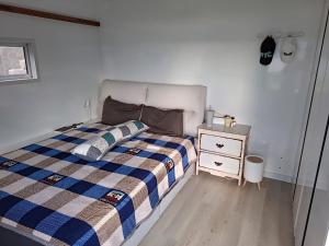 a bedroom with a bed and a night stand at ARA Caravan Villa in Bedugul