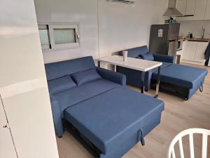 a living room with blue couches and a table at ARA Caravan Villa in Bedugul