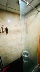 una ducha con pared de cristal en una habitación en Atha the luxury studio 5, en Noida