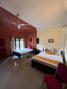 una camera d'albergo con due letti e una sedia di Sunbloom Hostel a Kandy