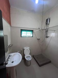 un bagno con lavandino, water e finestra di Sunbloom Hostel a Kandy