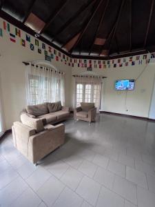 un soggiorno con un divano, una TV e delle bandiere di Sunbloom Hostel a Kandy Altre 14 foto