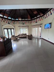 un ampio soggiorno con divano e TV a schermo piatto di Sunbloom Hostel a Kandy