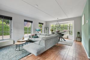 a living room with a couch and a table at Vakantiewoning Woudzicht - Stijlvol genieten in Nijkerk