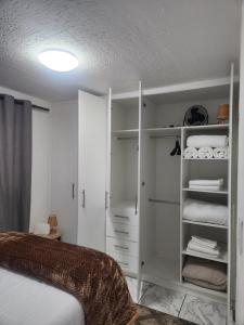 ein Schlafzimmer mit einem Bett und einem weißen Schrank in der Unterkunft Hayley's inn at village blues in Johannesburg