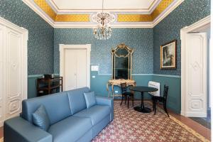 a living room with a blue couch and a table at Palazzo Giangreco Luxury Rooms in Avola