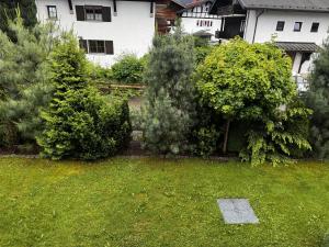 a yard with trees and bushes in front of a house at Ferienwohnung Lavendel in Oberstdorf