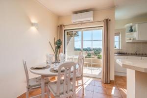 una cucina e una sala da pranzo con tavolo e sedie di T2 Plaza Resort a Portimão