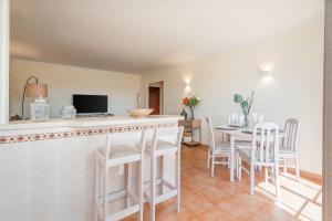 una cucina e una sala da pranzo con bar e tavolo di T2 Plaza Resort a Portimão