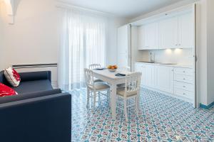 eine Küche und ein Esszimmer mit Tisch und Stühlen in der Unterkunft Lea Residenza Mediterranea Paestum in Paestum