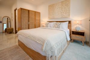 a bedroom with a large bed with white sheets and pillows at Tropical Kasbah Ubud Central - Private Studio Rooms in Ubud
