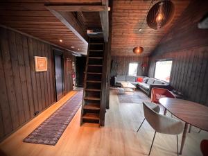 a living room with a spiral staircase in a house at Hytte på Norefjell in Surteberg