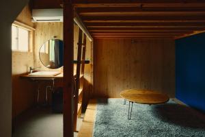 a room with a table and a sink and a bench at まちの別邸 緝 shu in Kochi
