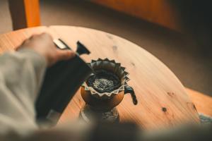 a person taking a picture of a pot on a table at まちの別邸 緝 shu in Kochi