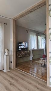 a living room with a tv and a wooden floor at White Hill's Nest in Zvejniekciems