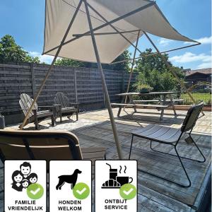 a patio with a table and an umbrella and chairs at Kunstmin in Zandvoorde