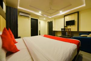 a bedroom with a bed and a couch and a television at Collection O Tip Top in Jaipur +37 photos