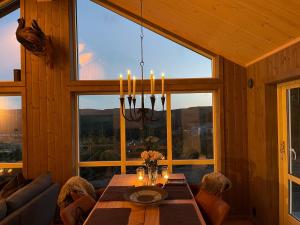 a dining room with a table and a large window at MYLLA - New cabin - Sauna - Hike - Bike - Canoe- Fishing in Jevnaker