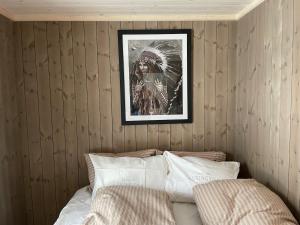 a picture hanging above a bed in a bedroom at MYLLA - New cabin - Sauna - Hike - Bike - Canoe- Fishing in Jevnaker