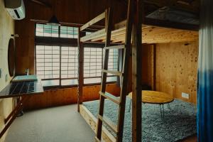 a room with two bunk beds and a window at まちの別邸 緝 shu in Kochi