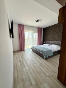 a bedroom with a bed and a large window at Apartament Lucas in Agigea