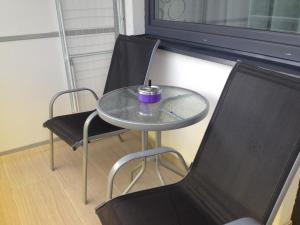 einen Tisch mit 2 Stühlen und einen Tisch mit einer Kerze darauf in der Unterkunft Rubin Apartman in Sárvár + 7 Fotos