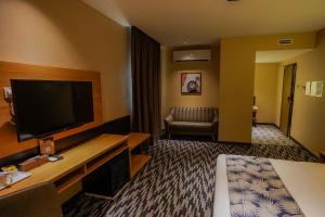 a hotel room with a flat screen tv and a couch at NB HOTEL in Johor Bahru