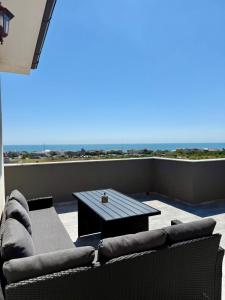 a patio with a couch and a table on a balcony at Apartament Lucas in Agigea