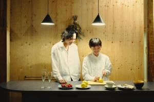 a woman and a child preparing food in a kitchen at まちの別邸 緝 shu in Kochi