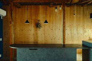 a kitchen with a counter and a wooden wall at まちの別邸 緝 shu in Kochi