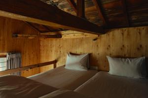 two beds in a room with wooden walls at まちの別邸 緝 shu in Kochi