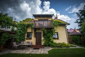 a house with a balcony and a table and chairs at Ardea Mikołajki domek in Mikołajki