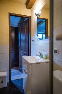 a bathroom with a sink and a mirror and a toilet at Ardea Mikołajki domek in Mikołajki