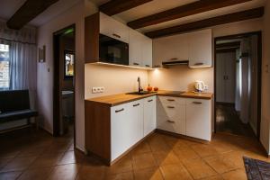 a kitchen with white cabinets and a counter top at Ardea Mikołajki domek in Mikołajki