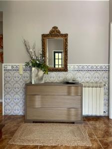 a dresser in a living room with a mirror at Villa dos Amados in Viana do Castelo