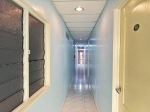 a hallway with a blue wall and a door at Darul Salam Orkid Inn in Dungun