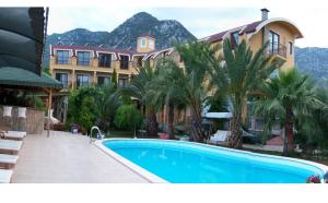 a resort with a swimming pool in front of a building at Papirus Hotel in Adrasan